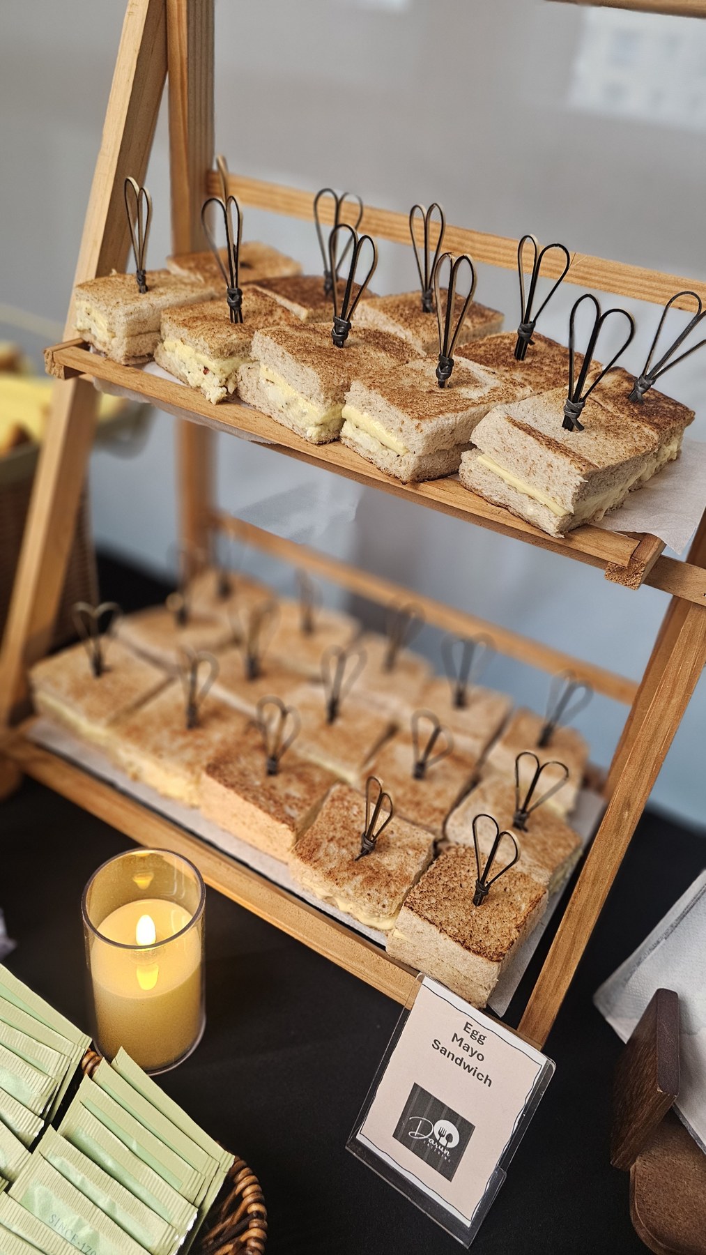 Sandwiches presented on tiered wooden refreshment stands