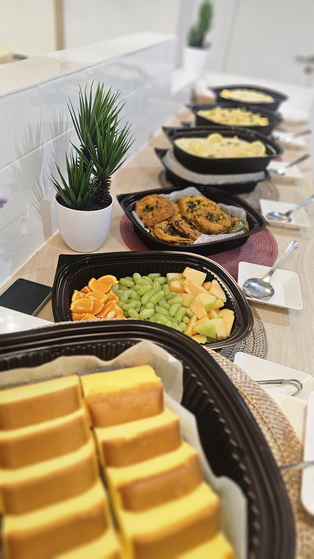 Individually packed black catering boxes with colourful meal selections